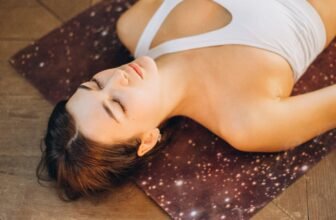 Femme relaxant sur un tapis de yoga avec bougies pour favoriser le sommeil