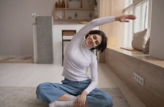 Femme souriante pratiquant le yoga chez elle avant de se coucher