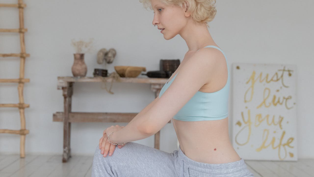 Femme réalisant une posture de yoga débutant à la maison